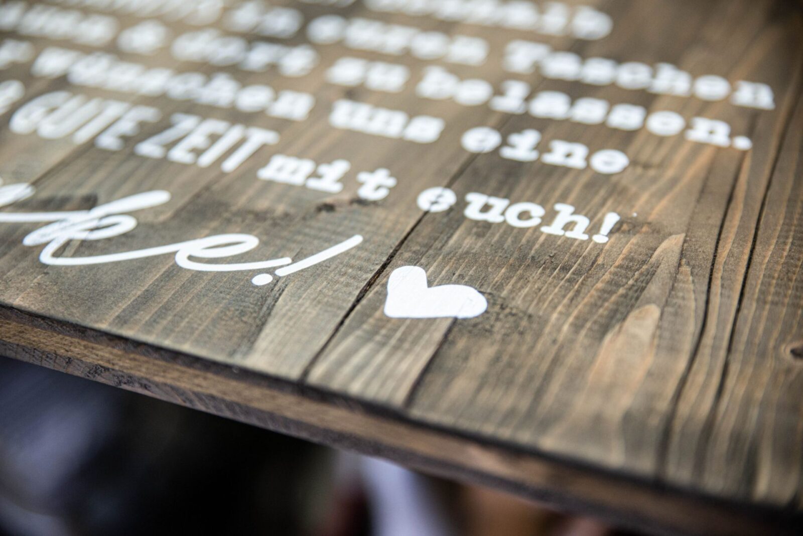 Weißdruck auf dunklem Holz für eine Hochzeit