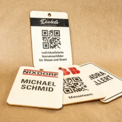 Mehrere individuell bedruckte Messebadges aus Holz, alternative zu Plastik- oder Papierausweisen