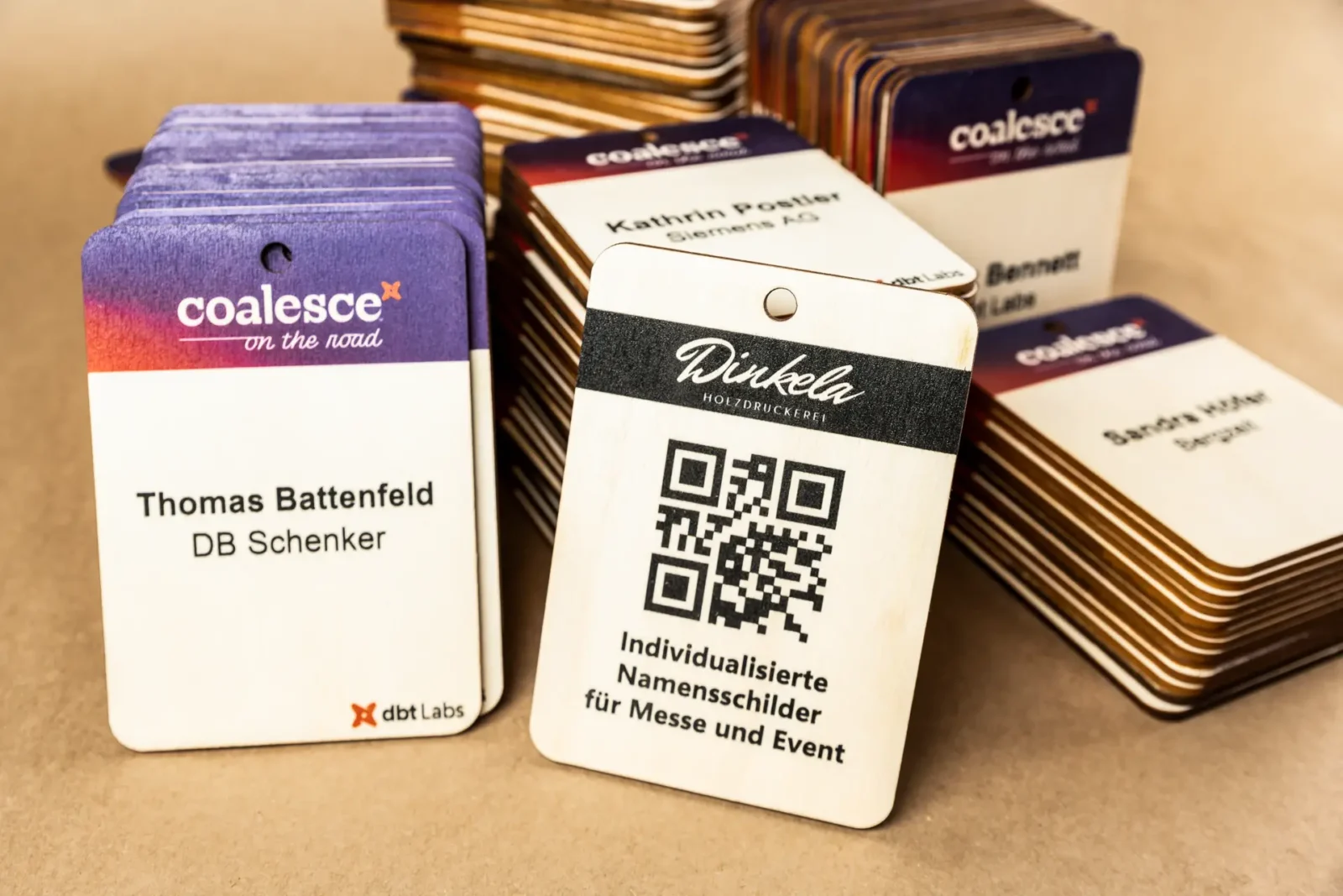 Große Menge individualisierter Holz-Badges in A6, farbig bedruckt für Events und Teilnehmermanagement