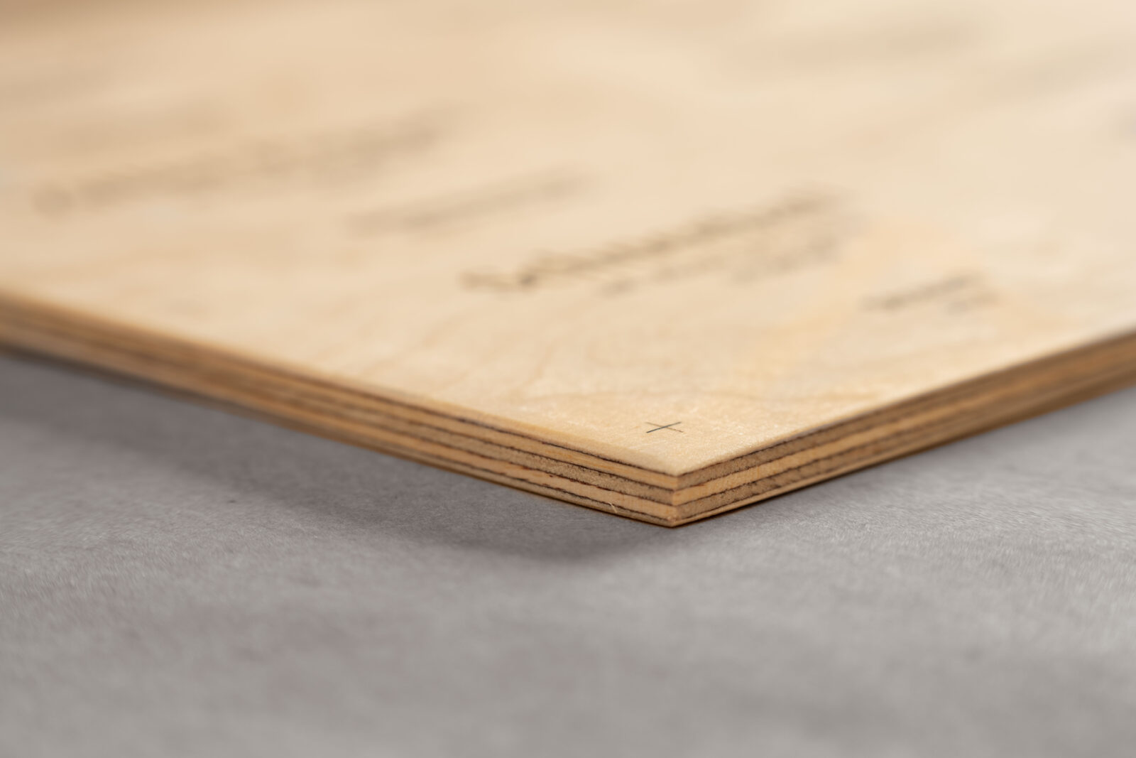 Nahaufnahme der Ecke eines Schildes aus Muliplex-Birke. Man sieht die mehreren Lagen des Multiplexes von der Seite sowie die Holztextur der ungrundierten Oberfläche