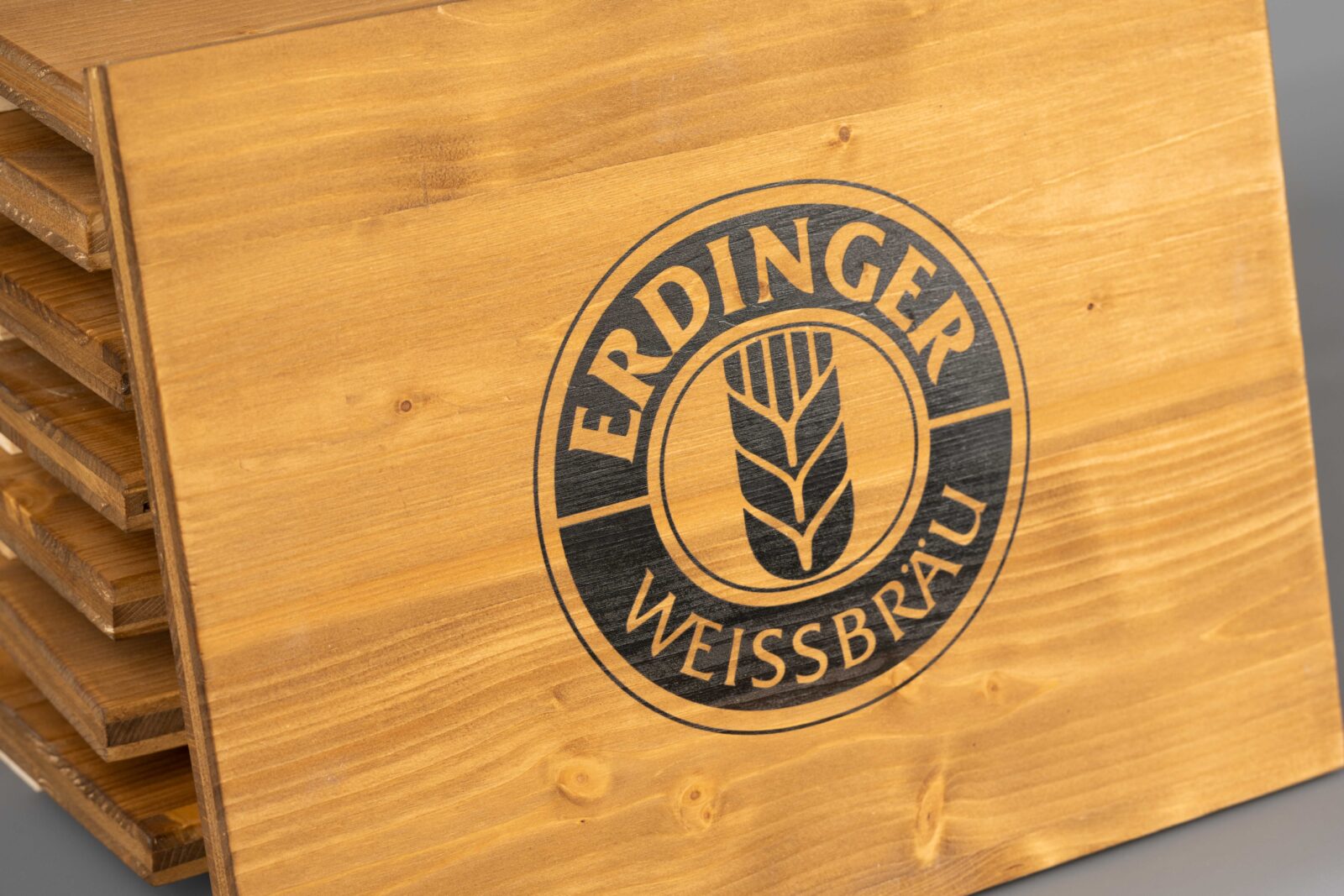 Sitzauflagen für Bierkisten mit Brauerei-Logo zentriert bedruckt. Man sieht die schöne Maserung des Holzes.