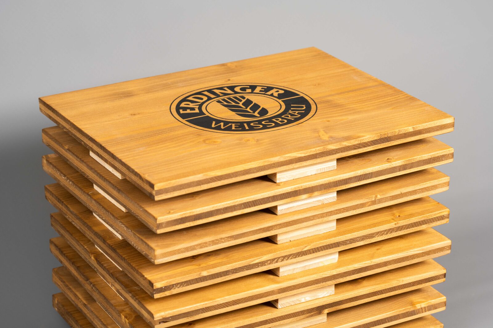 Ein Stapel von Sitzauflagen aus Holz für Getränkekästen.