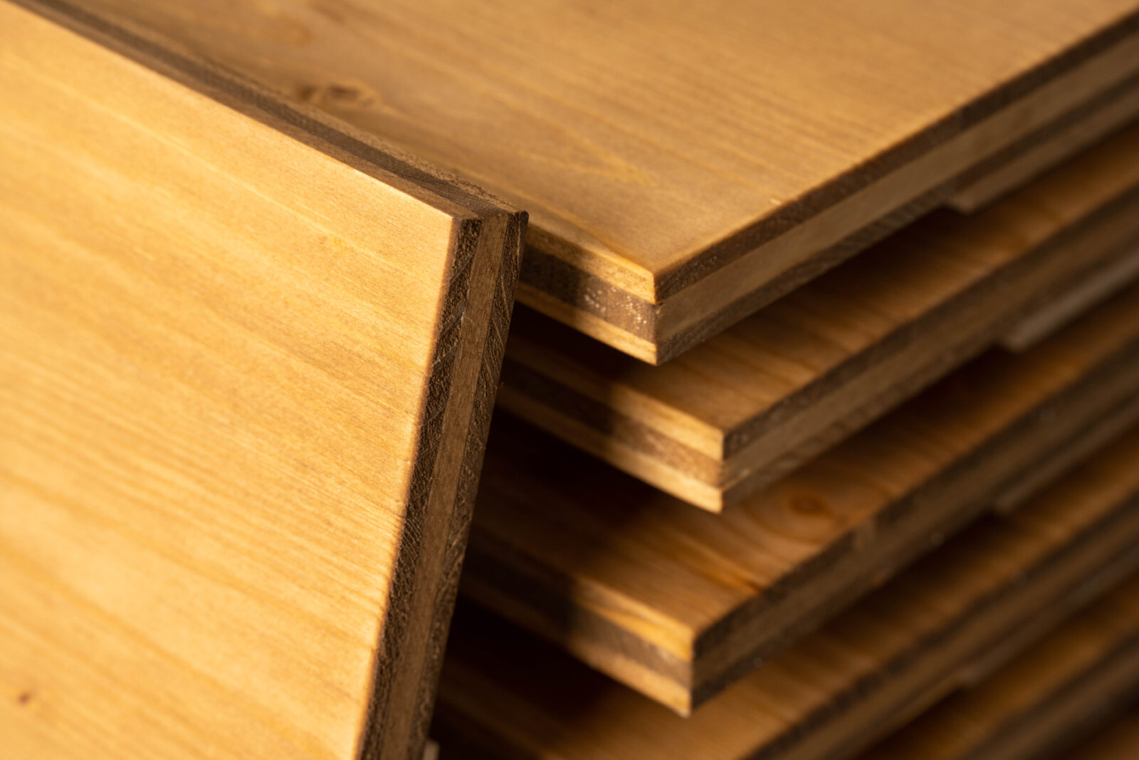 Nahaufnahme von farblich warm gebeizten Holzkanten von Bierkistenauflagen.