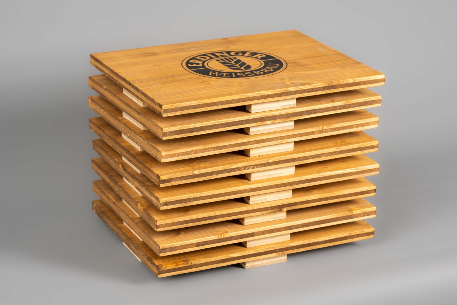 Ein Stapel von Bierkistenauflagen aus Holz, welche man als Sitzfläche auf Getränkekisten benutzen kann.