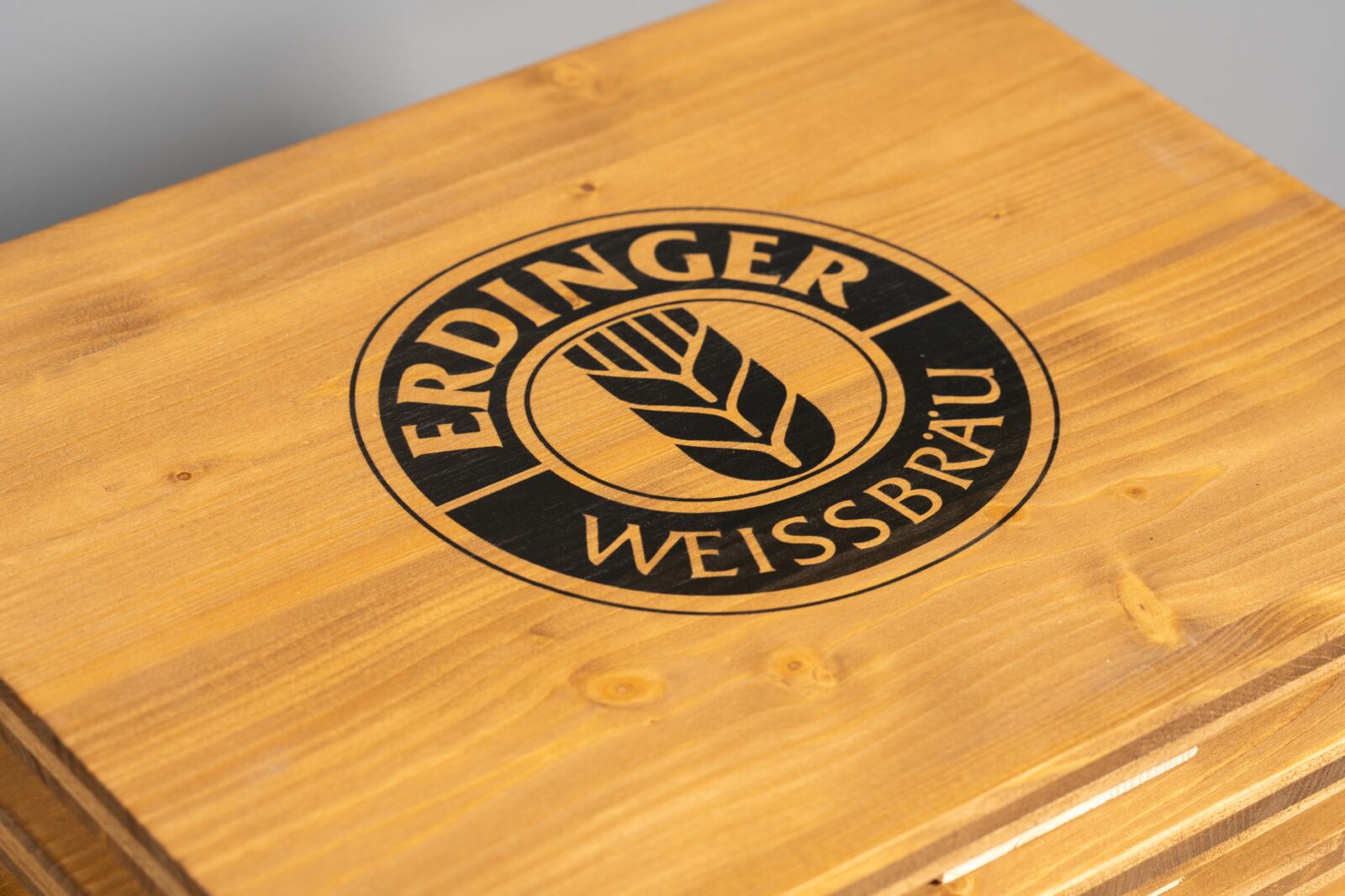 farblich warme, gebeizte Bierkistenauflage mit Brauerei-Logo in schwarz gedruckt