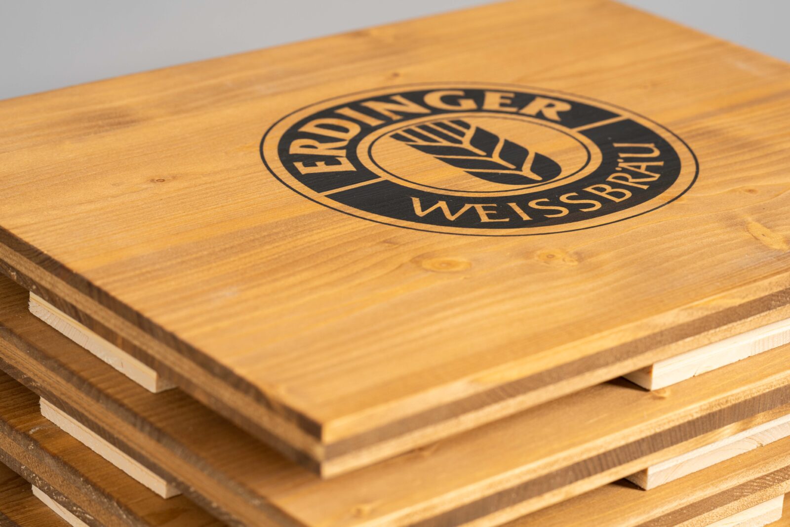 farblich warme, gebeizte Bierkistenauflage mit Brauerei-Logo in schwarz gedruckt