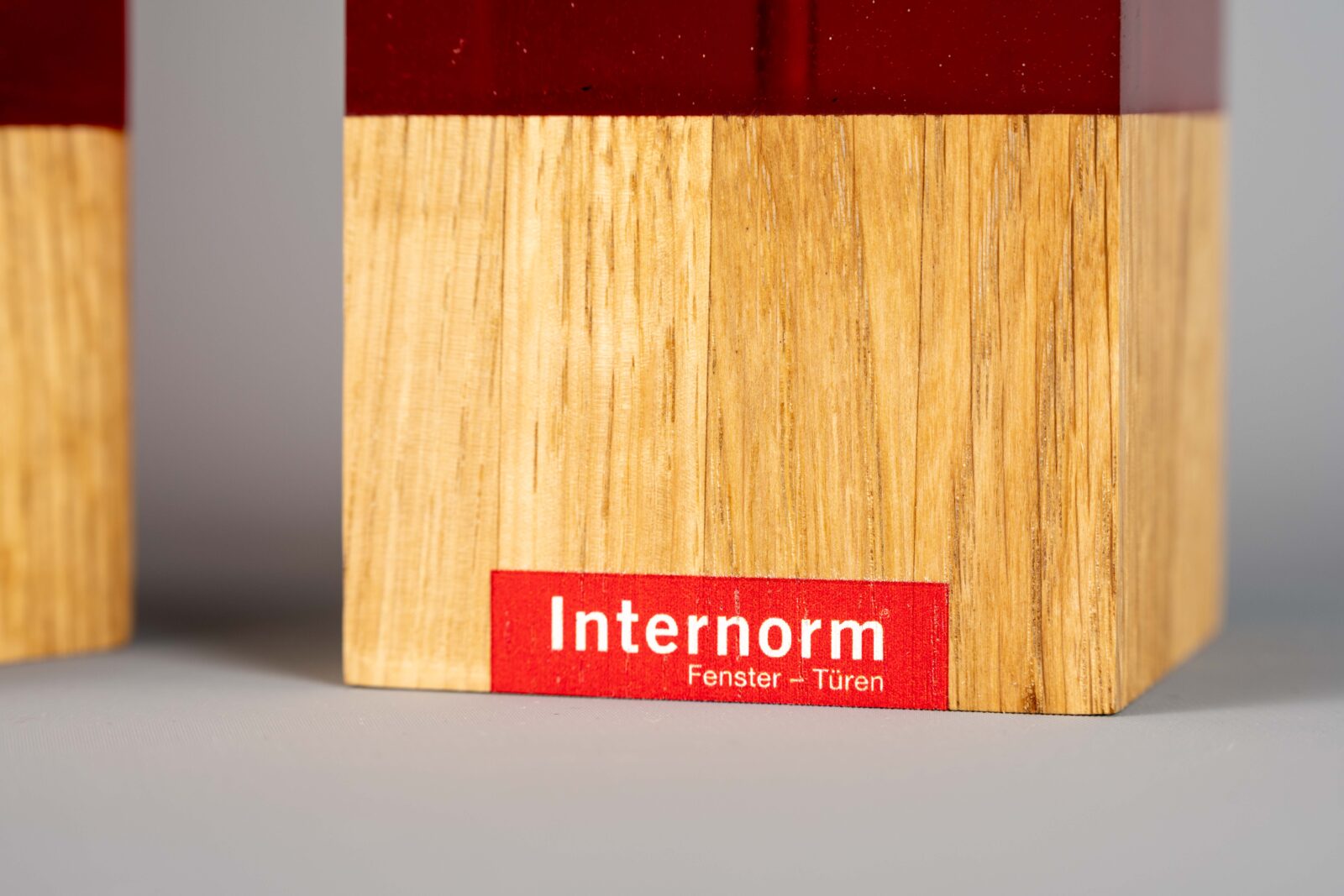 Eine Detailaufnahme von dem massiven Eichenholz des Pokals, mit Firmenlogo bedruckt.