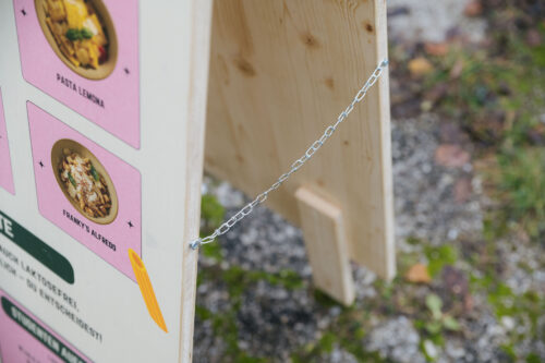 Detailaufnahme der Sicherungskette eines Holz-Kundenstoppers