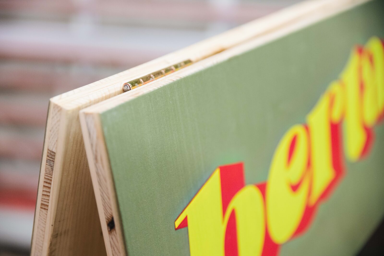 Detailaufnahme der Metallscharniere eines Holz-Kundenstoppers