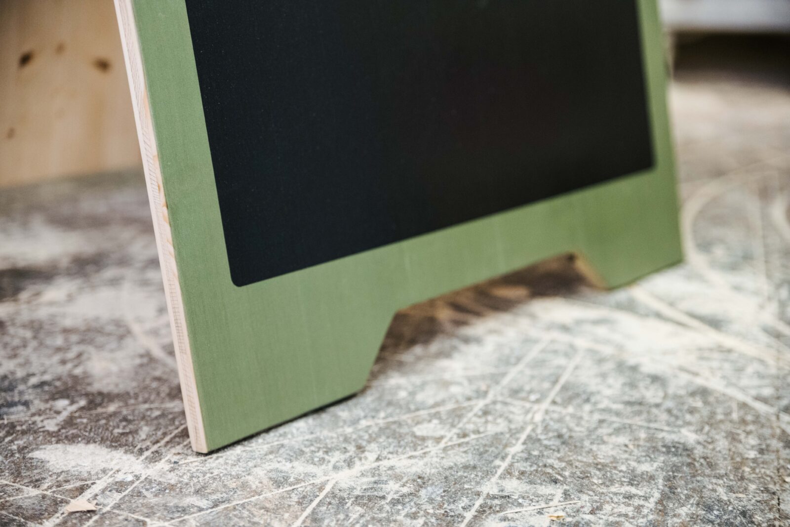 Nahaufnahme des Fußes eines Kundenstoppers aus Holz. In der Werkstatt zu sehen wo es hergestellt wurde.