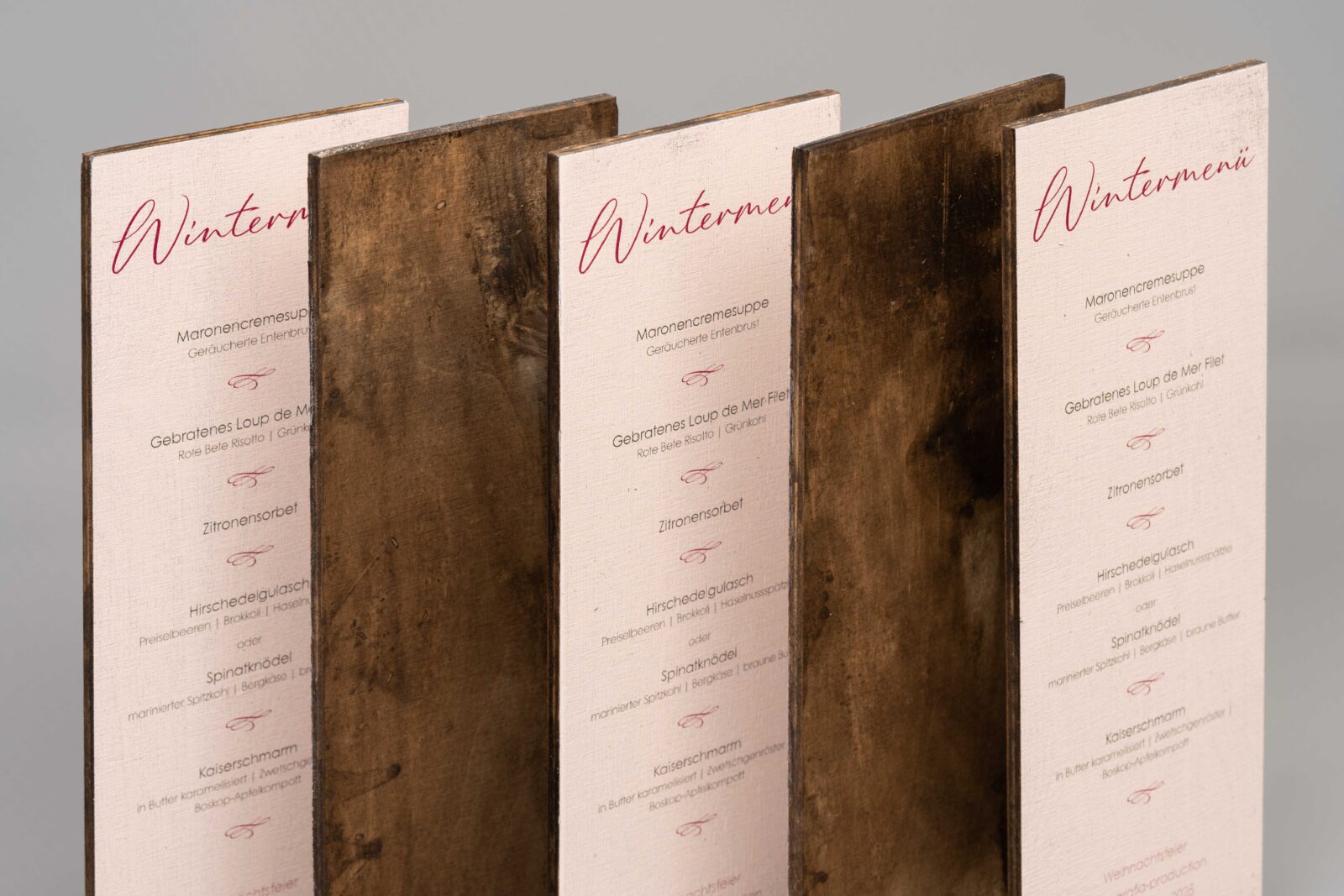 Serie aus fünf stehenden Multiplex-Schildern mit bedruckter Vorderseite und dunkel gebeizte Rückseite.