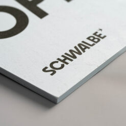 Nahaufnahme von schwarzem Text gedruckt auf hellblauem Hintergrund eines Multiplex-Schildes.