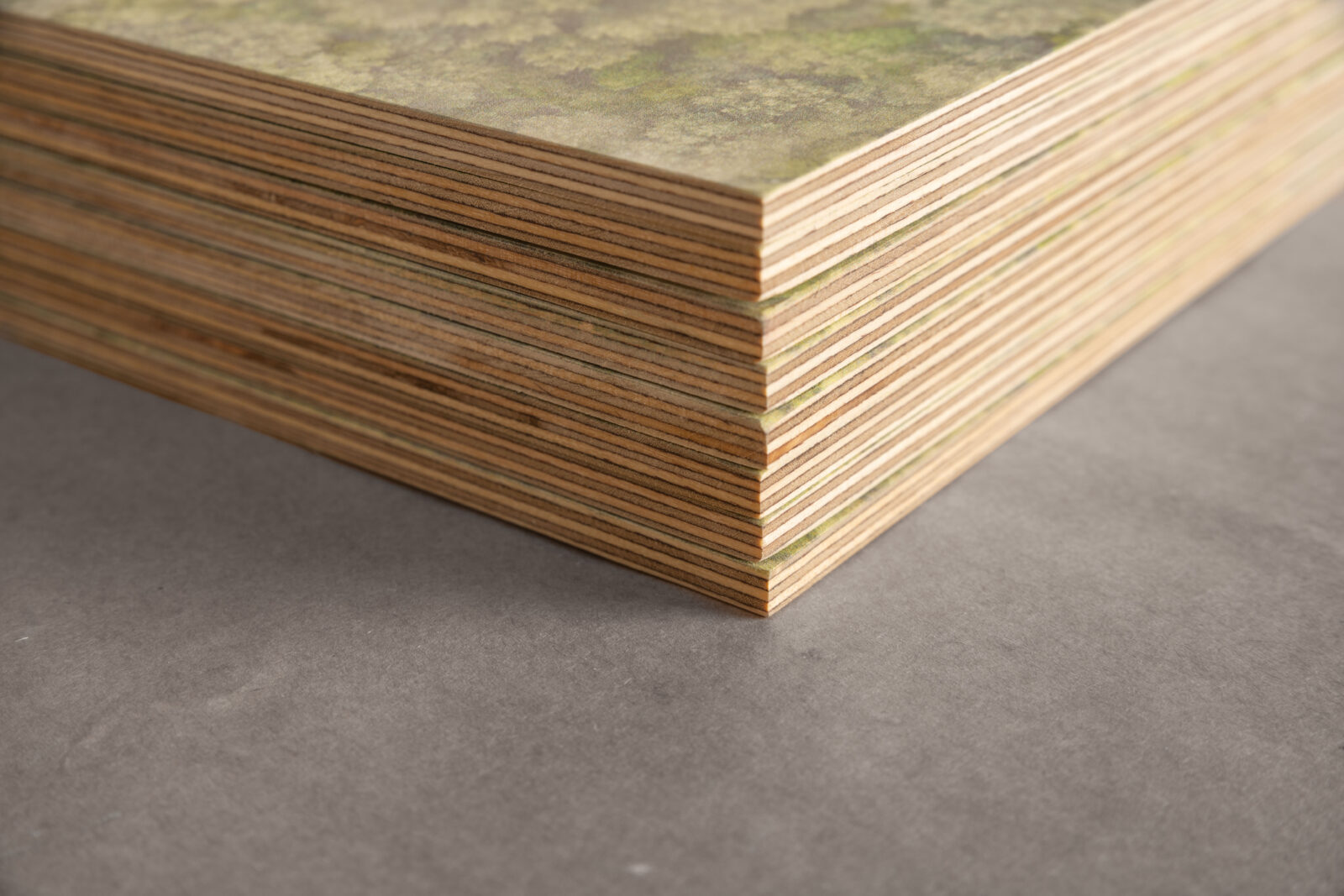 Ein Stapel von bedruckten Multiplex-Schilder. Man sieht eine Ecke und Kanten mit mehreren Lagen.