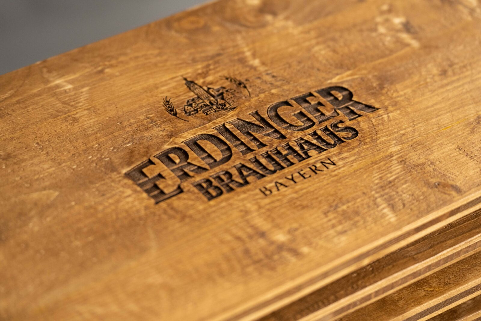 Detailaufnahme der rauen Oberfläche einer breiten Bierkistenauflage für zwei Kisten aus Altholz mit sichtbarer Holzmaserung