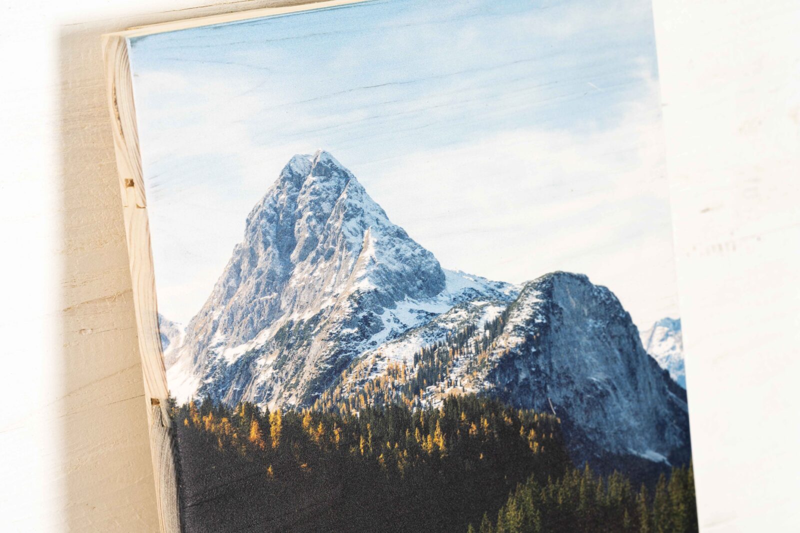 Nahaufnahme der Oberfläche von einem Fotodruck auf neue Holzlatten. Man sieht die Maserung des Holzes am Himmel des Fotos.