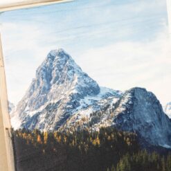 Nahaufnahme der Oberfläche von einem Fotodruck auf neue Holzlatten. Man sieht die Maserung des Holzes am Himmel des Fotos.