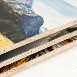 Ein Stapel von mehreren Bildern auf neuen Holzlatten gedruckt. Man sieht die Seitenkante, wo die Struktur der Holzlatten klar zu sehen ist.