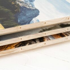Ein Stapel von mehreren Bildern auf neuen Holzlatten gedruckt. Man sieht die Seitenkante, wo die Struktur der Holzlatten klar zu sehen ist.