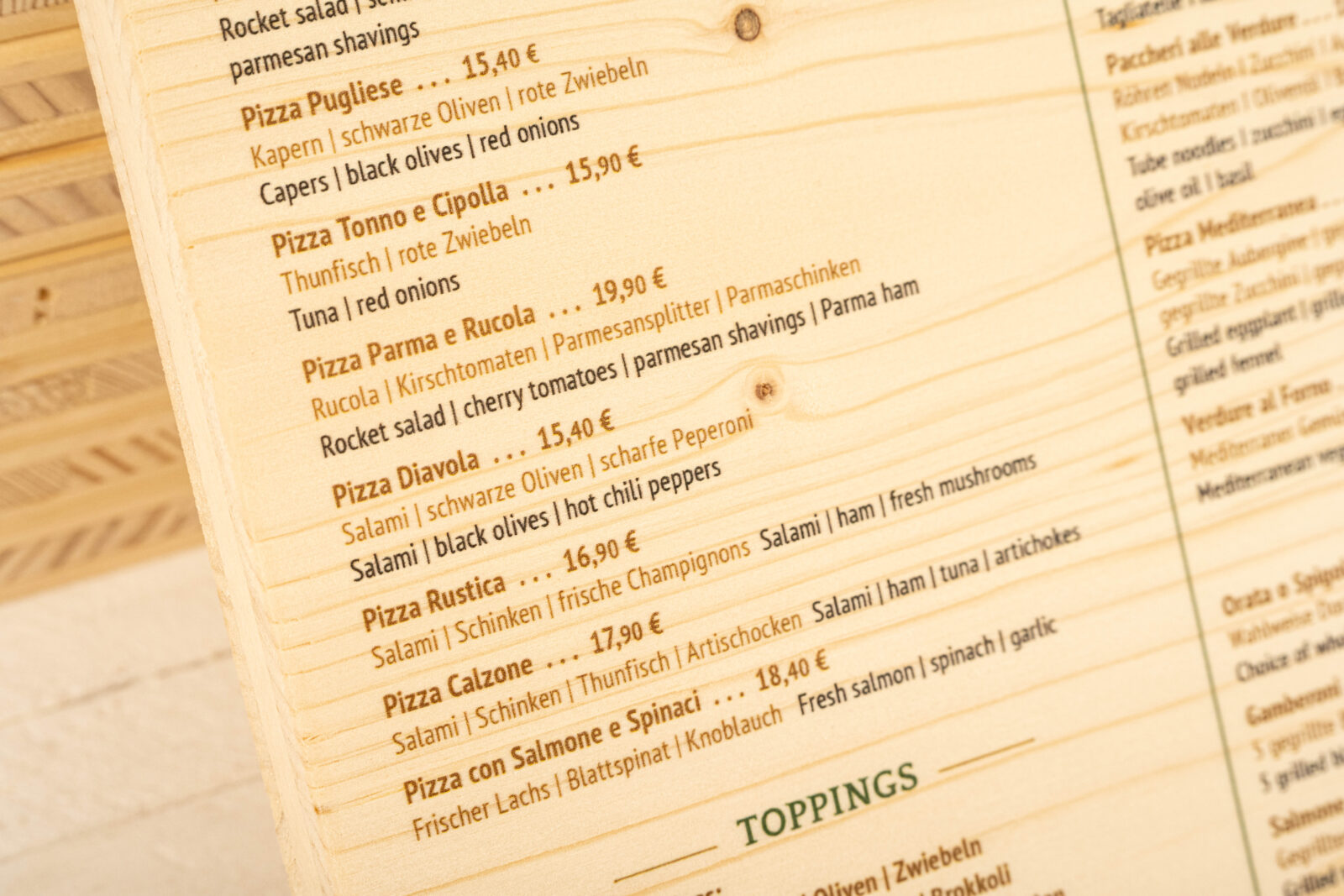 Speisekarte aus Fichtenholz mit direkt gedrucktem Text auf der Holzoberfläche - Detailaufnahme vom Text